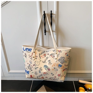Detail of white tote bag showing colorful graffiti patterns and luck lettering text