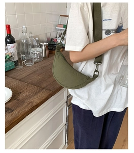 Détail du sac croissant en nylon vert armée avec large bandoulière et attaches résistantes