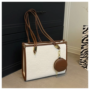 Detail of white leather tote with brown trim and small round coin purse attachment