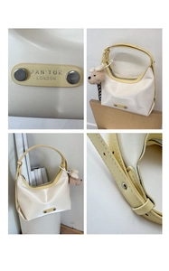 Detail view of cream leather tote with yellow trim, silver hardware and plush dog charm