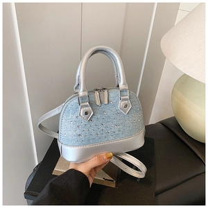 Détail du sac à main en denim bleu clair avec strass brillants et poignées argentées