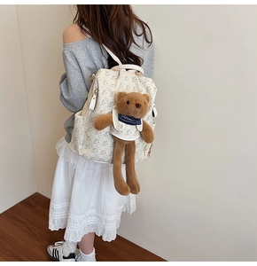 Detail of printed large capacity backpack with a cute plush bear charm for women