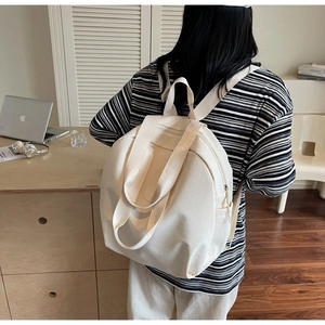 Modell mit cremefarbenem Segeltuch-Rucksack in einer gemütlichen Büroumgebung