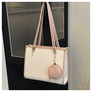 Detail of embossed clover pattern on cream tote bag with pink trim and mini coin purse