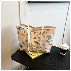 Détail du sac cabas en toile avec graffitis colorés sur une table en bois