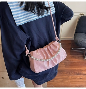 Borsa a nuvola in vernice rosa con catena di perle indossata da una modella