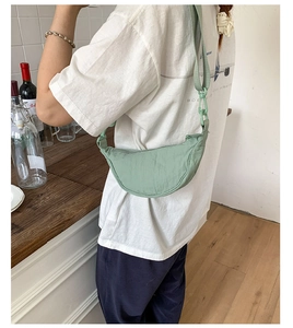 Détail du sac croissant en nylon vert menthe avec tissu plissé et bandoulière à chaîne