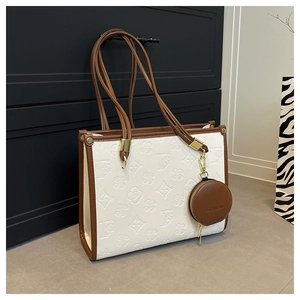 Detail of embossed floral patterns and brown contrast trim on the luxury tote bag
