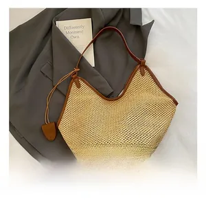 Détail du sac cabas en paille tressée avec garniture en cuir brun et maille fine
