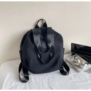 Schwarzer leichter Nylon-Rucksack in Lifestyle-Szene mit Laptop und Kopfhörern gezeigt