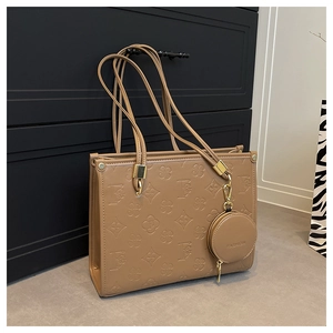 Close-up of tan PU leather tote bag with floral embossed patterns and coin purse