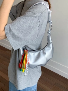 Silver metallic crescent moon shoulder bag with knotted strap and colorful tassels