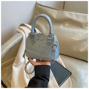Détail du sac à main bleu clair en denim avec strass brillants et finitions argentées