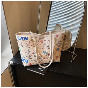 Vue détaillée du grand sac cabas en toile blanche avec imprimés graffiti et anses robustes