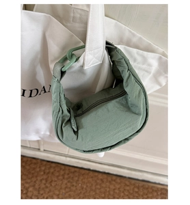 Détail du sac dumpling en nylon vert citron utilisé comme accessoire sur un cabas