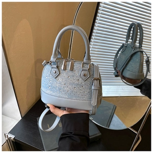 Détail du sac à main bleu clair en denim avec strass brillants et double fermeture éclair
