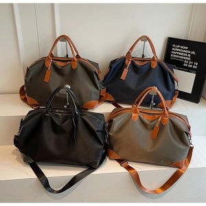 Detail showing various colors of large nylon travel duffel bags with leather accents
