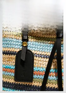 Vue détaillée de la texture tissée à rayures colorées et de la bandoulière en cuir