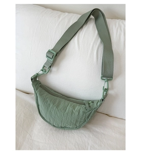 Détail du sac croissant en nylon vert sauge avec bandoulière réglable et fermeture éclair