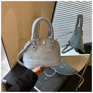 Détail d'un sac coquillage bleu clair avec paillettes argentées et cristaux en miroir