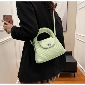 Detail of mint green quilted bag with silver twist lock and pleated side textures
