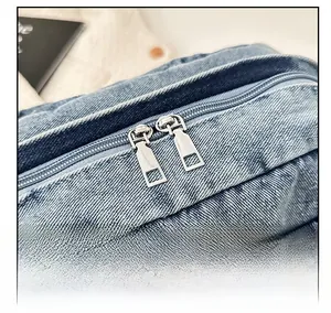 Close-up of smooth silver dual-zipper closure on premium denim crossbody bag