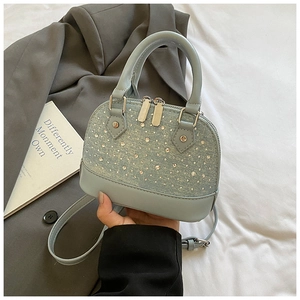Détail du mini sac dôme bleu clair orné de strass argentés et d'une bandoulière réglable