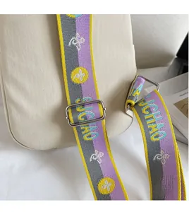Détail d'une large bandoulière tissée réglable avec rayures colorées et boucle en métal