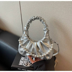 Dettaglio borsa a nuvola argento plissettata con catena di perle e manico scrunchie