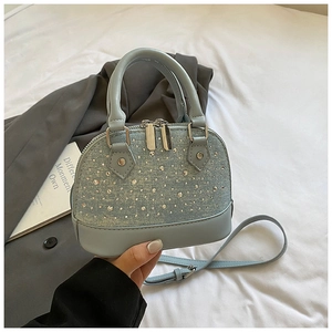 Vue détaillée du sac coquillage bleu clair orné de strass brillants et double fermeture