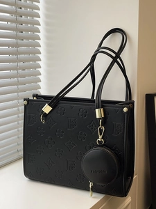 Large black leather tote bag with embossed floral pattern and small round coin purse charm