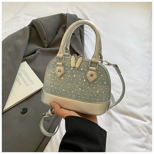 Détail du mini sac coquille en denim et cuir argenté avec des ornements en strass brillants