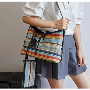 Détail du sac cabas tissé aux rayures colorées avec des bandoulières en cuir noir de qualité