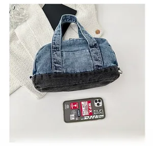 Detail view of large denim pillow handbag featuring light blue and grey wash patchwork design