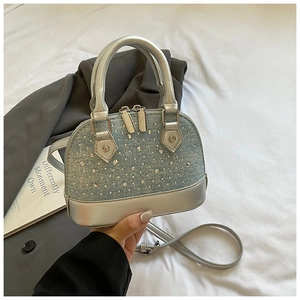Détail du mini sac coquille en denim bleu avec strass argentés et bandoulière
