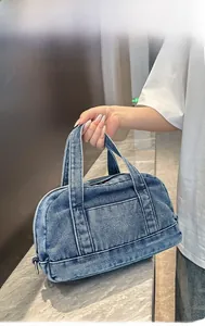 Detailed shot of a vintage washed denim handbag with double handles and front pocket