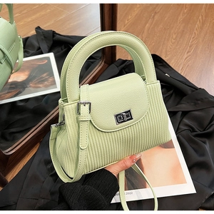 Detail of light mint green quilted crossbody bag with pleated texture and silver twist lock