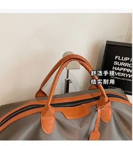 Detail showing the reinforced leather handles and brand logo on a large travel bag