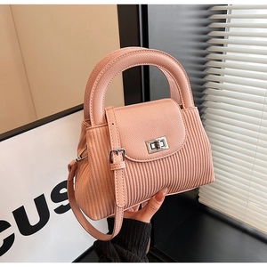 Detail of pink pleated texture leather handbag with silver twist lock and handle