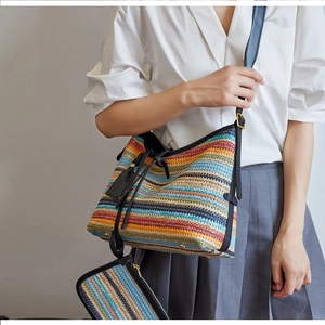 Gros plan sur la texture tissée colorée et le cordon en cuir noir du sac à main