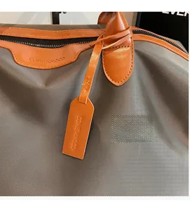 Close-up of durable grey striped fabric and premium brown leather details of the travel bag