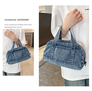 Detail of dark blue washed denim handbag with cylindrical shape and dual handles