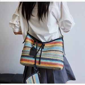 Vue détaillée arrière d'un sac bandoulière tissé à rayures avec lanière en cuir et pochette