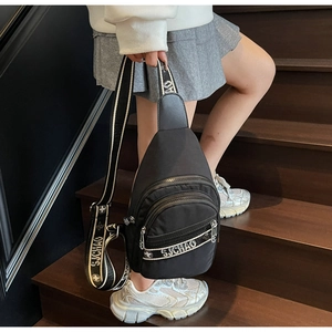 Détail du sac à bandoulière en nylon noir avec poches zippées et sangle imprimée