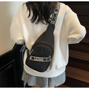 Gros plan du sac bandoulière noir avec logo SJCHAO porté sur un sweat à capuche