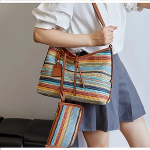 Détail du sac cabas tissé à rayures colorées avec lanières en cuir marron et pochette
