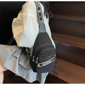 Gros plan sur le sac de poitrine en nylon noir avec double fermeture éclair et bandoulière