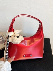 Red glossy half-moon tote bag with a zipper and a cute beige plush dog keychain