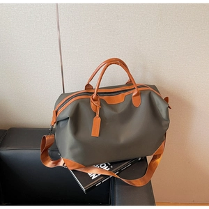 Detail of olive green travel bag with leather handles and wide shoulder strap