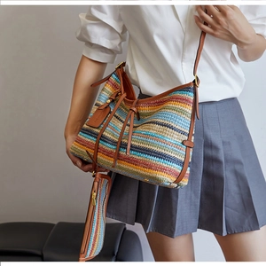 Détail du sac cabas tissé à rayures colorées avec bordure en cuir marron et petite pochette